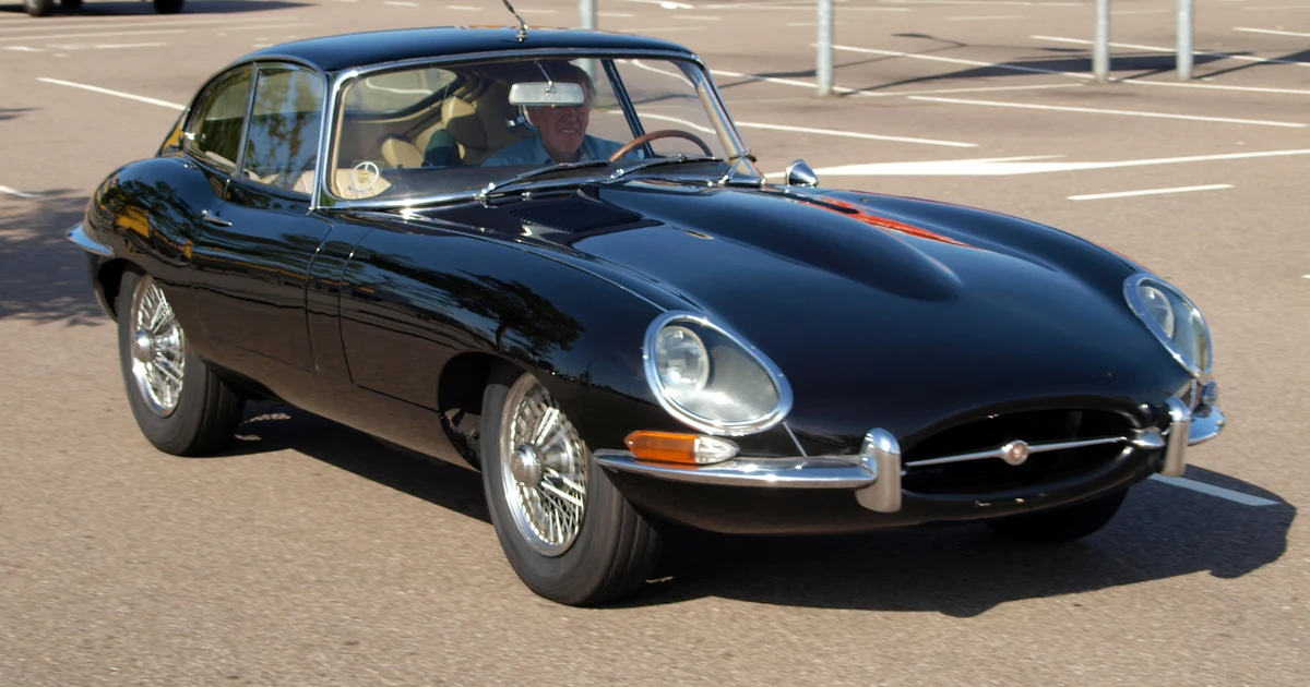 A classic black Jaguar E-Type sports car, photographed from the front three-quarter angle.