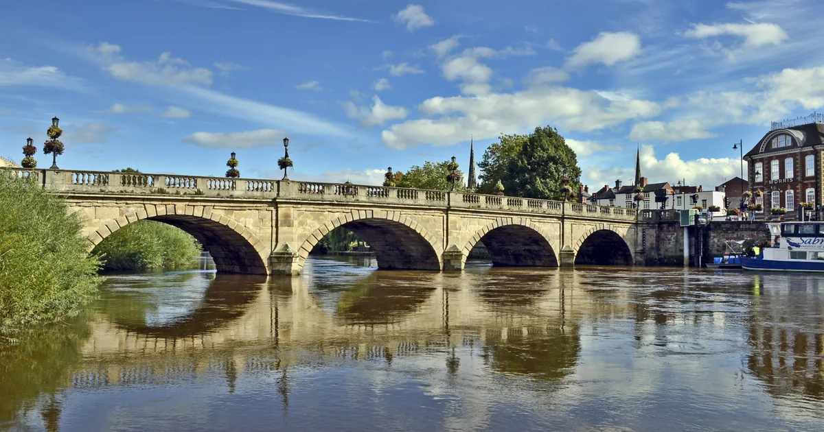 The Welsh Bridge over the River Severn in Shrewsbury, Shropshire, with the town's buildings behind.