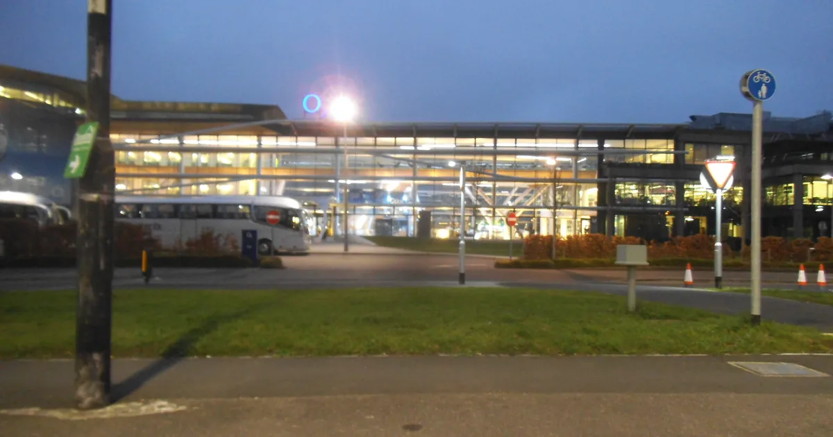 The O2 offices on Bath Road, Slough, lit up at dusk, seen across a road junction.